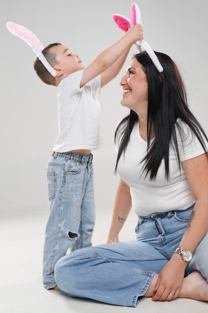 Portrait de famille en studio montrant un moment de rire et de tendresse spontané entre une mère et son fils.