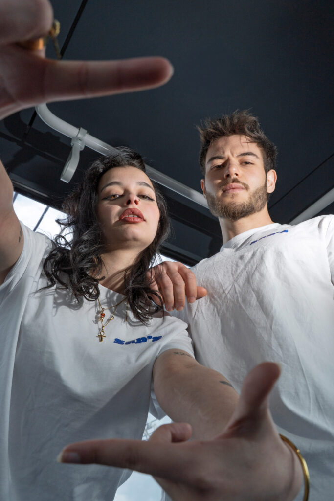 Prise de vue en contre-plongée de deux modèles en t-shirts blancs lors d'un shooting photo de mode urbaine à Toulouse.