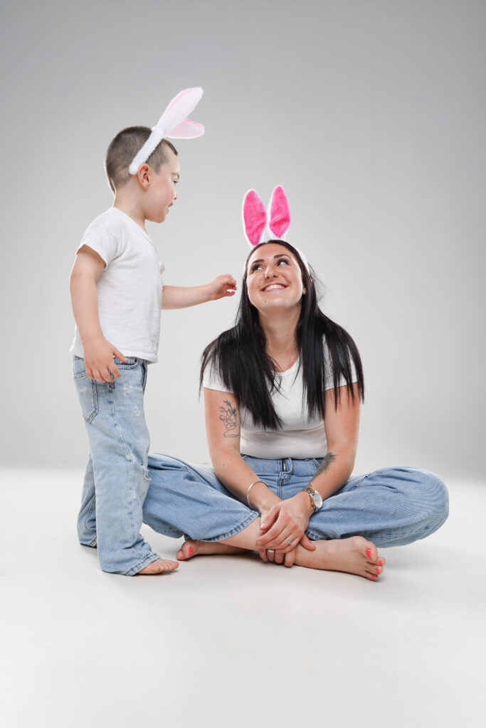 Séance photo studio amusante et complice entre une maman portant des oreilles de lapin et son jeune garçon à Carcassonne.