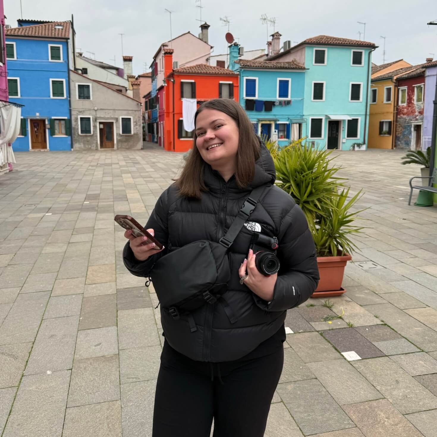 Portrait de Julie Pouppeville, photographe en Occitanie, tenant son appareil photo lors d'un reportage.
