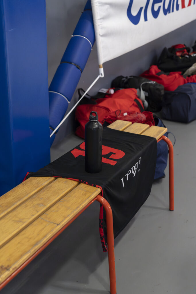 Gourde et maillot noir sur un banc de touche lors d'un reportage de photographie de handball pour le club de Palaja.