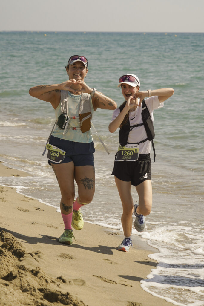 Deux coureuses complices et souriantes sur la plage pendant l'événement sportif du Biquet Trail.