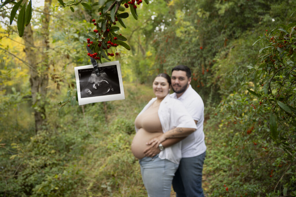 Photographe de grossesse en Occitanie : shooting photo d'un futur couple de parents en forêt mettant en valeur le ventre rond.