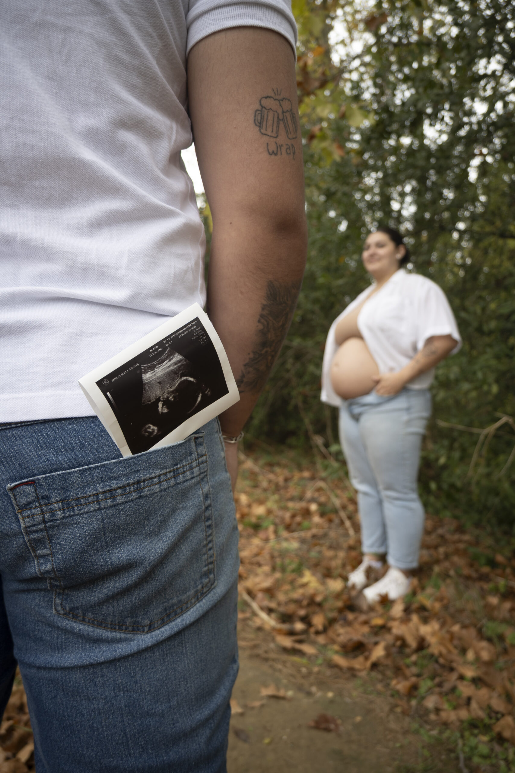 Shooting photo grossesse et famille en Occitanie - futurs parents de dos montrant l echographie du bébé